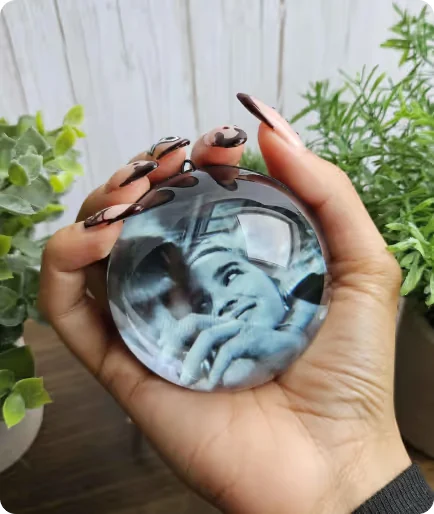 Memory Pearl held in a hand, playing a black and white portrait